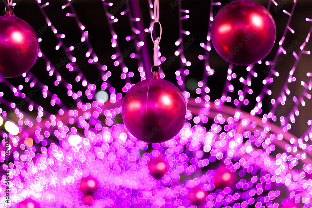 Fototapeta premium Red Christmas balls with blurred lights at the background.