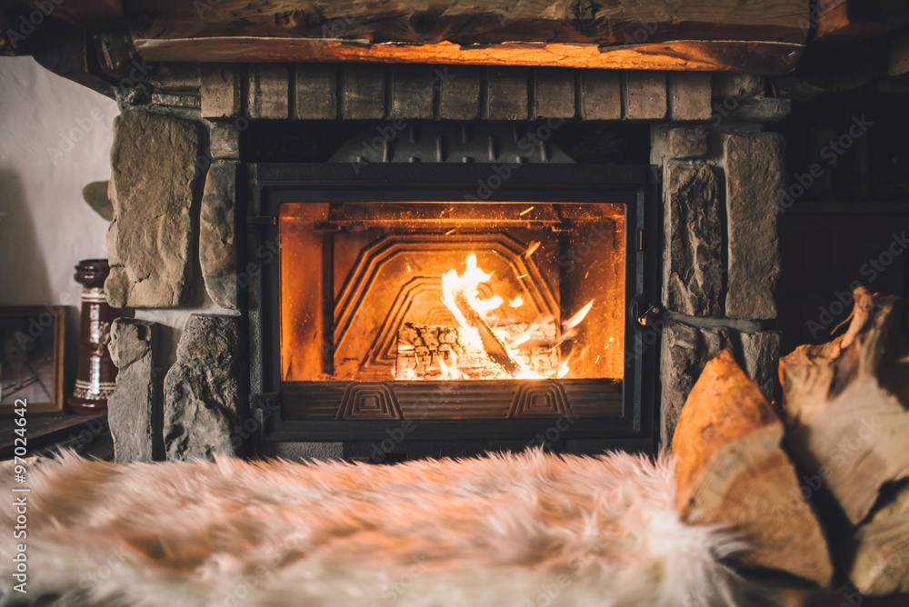 Warm cozy fireplace with real wood burning in it. Cozy winter concept.  Christmas and travel background with space for your text Stock Photo |  Adobe Stock