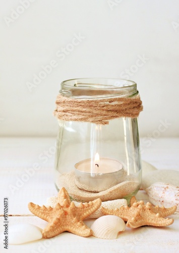 
Votive candles tea light in jars with sea sand, sea shells. Marine style home accessories for beach themed interior decorating