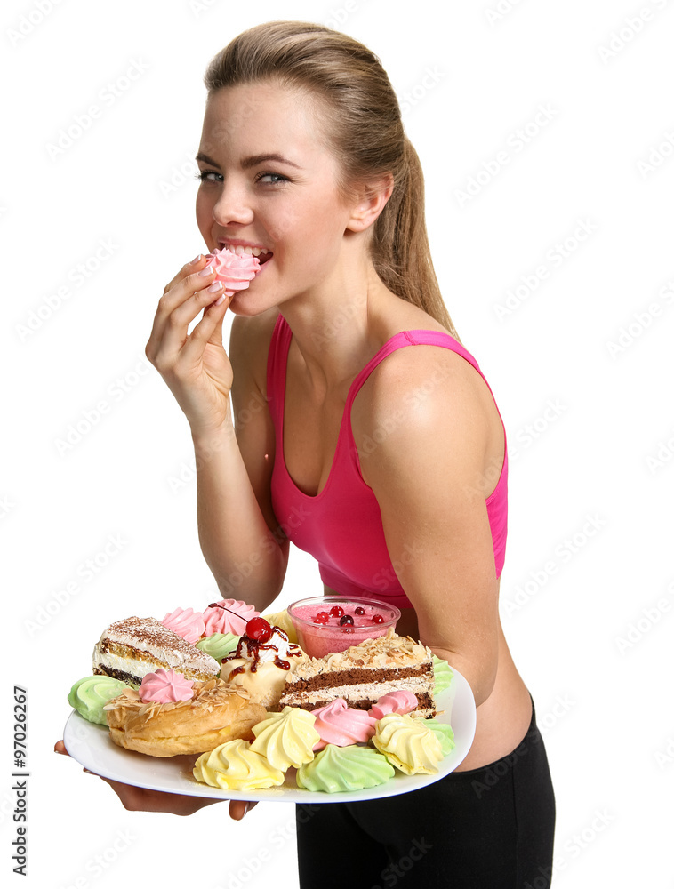 Woman eating cupcake and smiling / photo set of sporty muscular female brunette girl wearing sports clothes isolated on white background Woman eating cupcake and smiling / photo set of sporty muscular female brunette girl wearing sports clothes isolated on white background