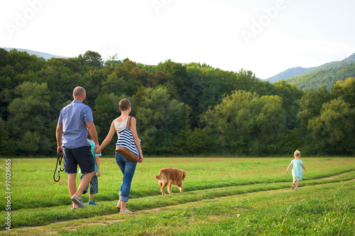 Beautiful young family with their pet dog, golden retriever © andreaobzerova