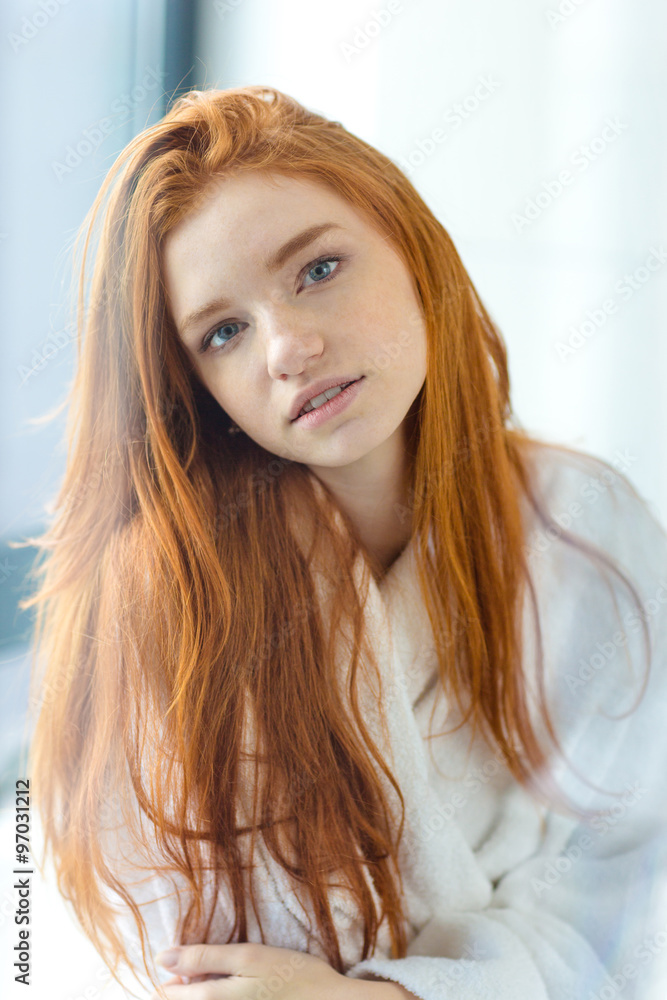 Redhead woman in bathrobe looking at camera Redhead woman in bathrobe looking at camera