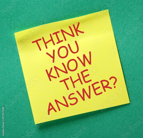 The phrase Think You Know The Answer in red text on a yellow sticky note posted on a green notice board
