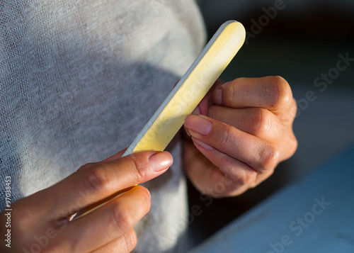 Frau reinigt und manikürt Ihre Fingernägel