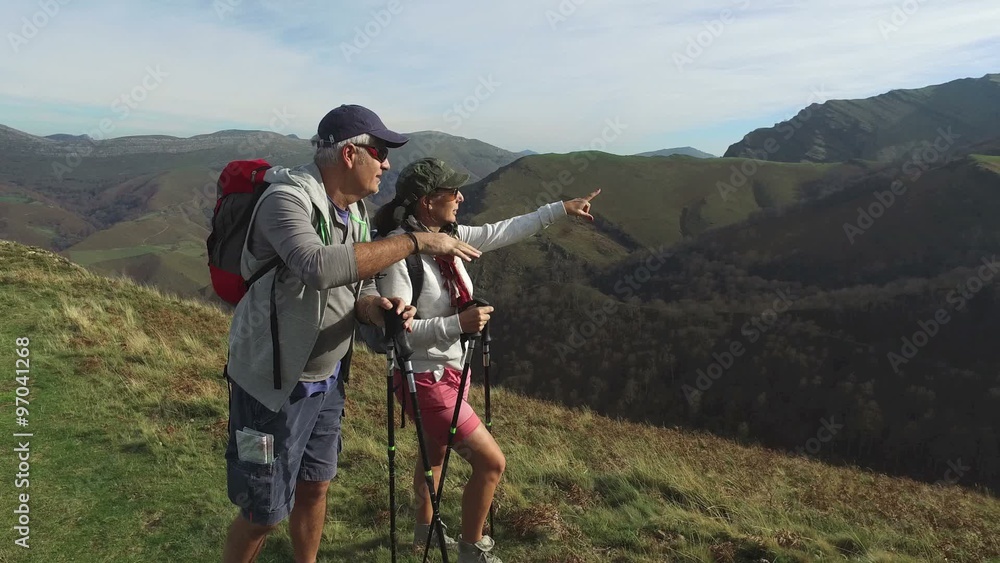 Couple of trekkers hiking in mountain scenery Couple of trekkers hiking in mountain scenery