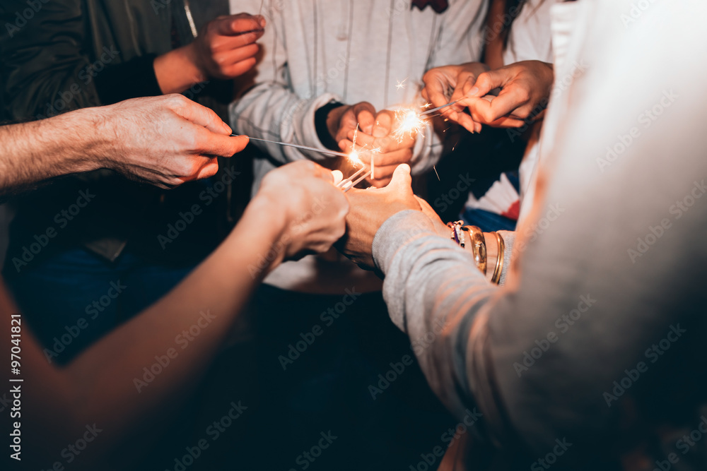 Friends celebrating new year's eve with sparklers - obrazy, fototapety, plakaty 