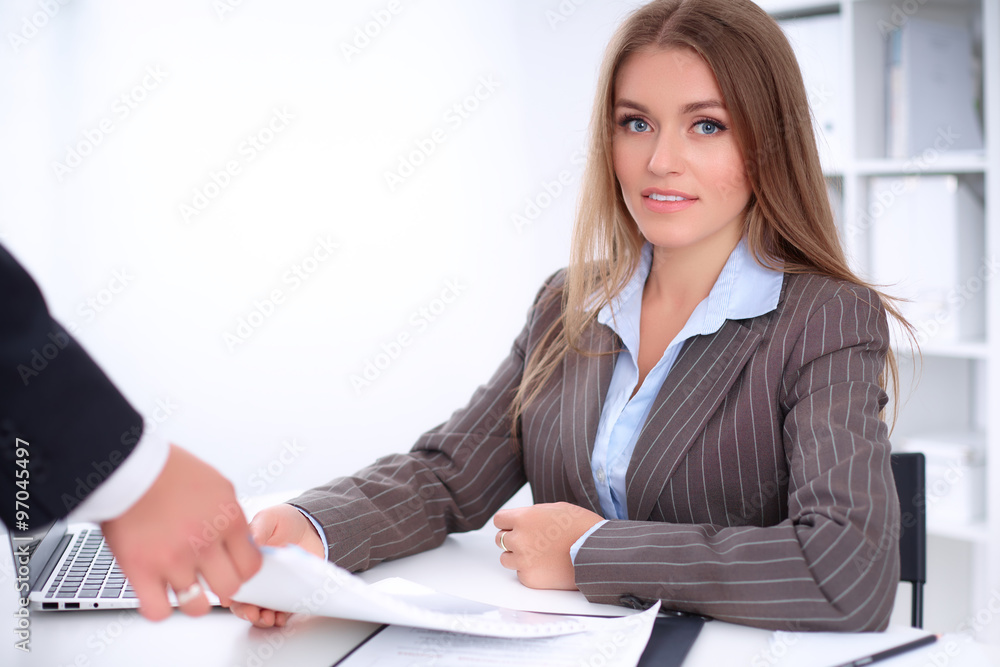 Young business woman is taking finance report sitting at the table against the background of the office Young business woman is taking finance report sitting at the table against the background of the office