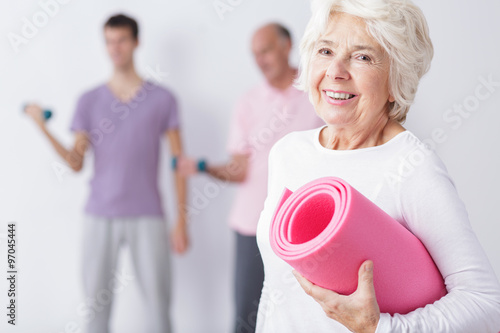 Happy elderly woman at gym
