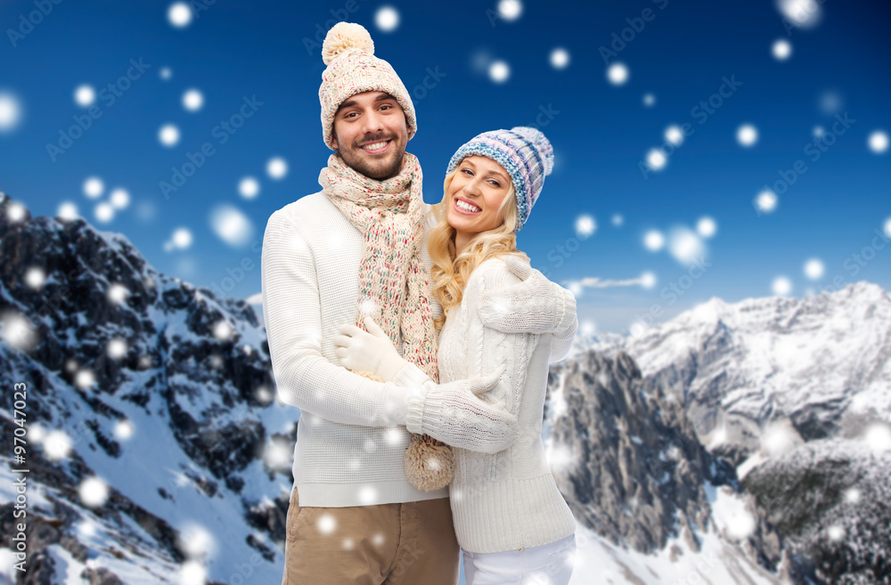 couple in winter clothes over snowy mountains couple in winter clothes over snowy mountains