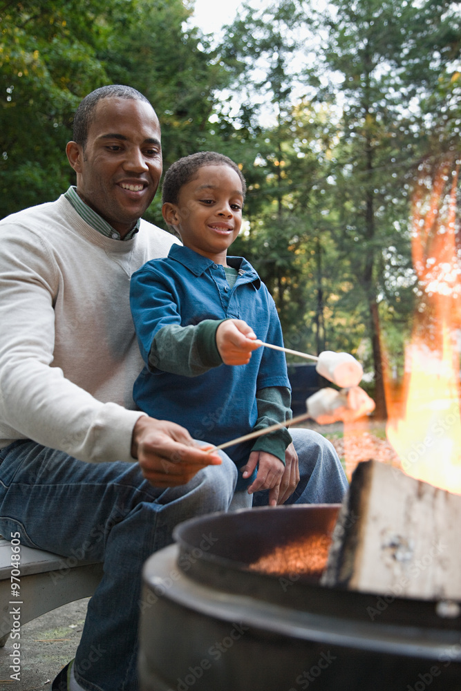 Naklejka premium Father and son toasting marshmallows