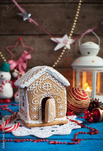 Homemade gingerbread house with candy windows on a blue wooden table