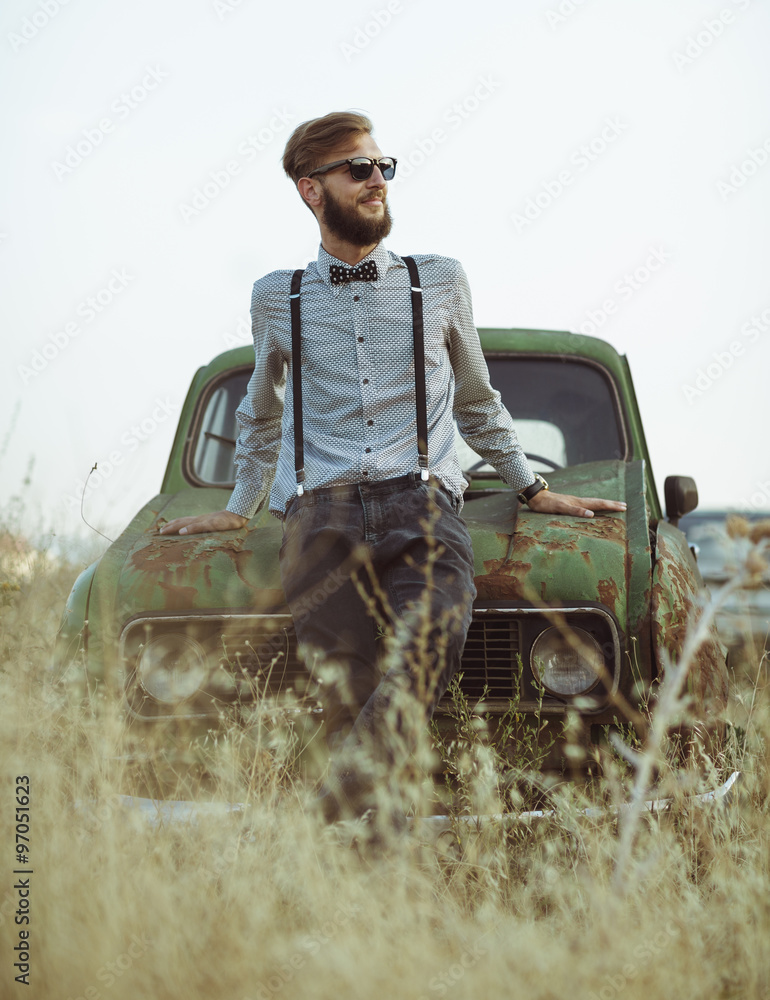 Obraz premium Young handsome stylish man, wearing shirt and bow-tie with old c