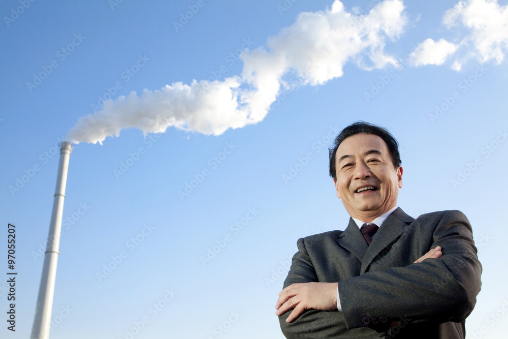 Businessman in Front of Smokestack Businessman in Front of Smokestack
