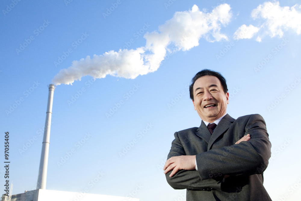 Businessman in Front of Smokestack Businessman in Front of Smokestack