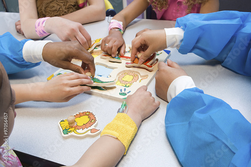 Children and nurses playing with puzzle