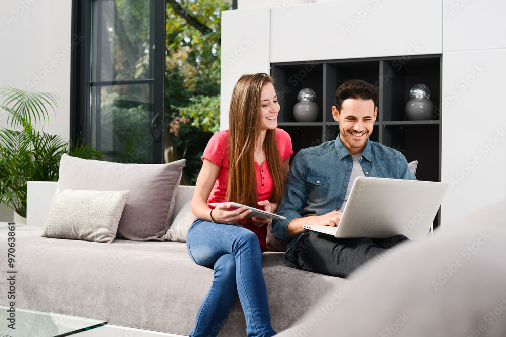 cheerful young couple man and woman in sofa at home with laptop computer cheerful young couple man and woman in sofa at home with laptop computer