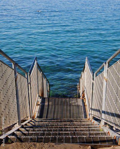 steps to the transparent Adriatic sea waters on the free strand of Barcola, Trieste, Italy photo