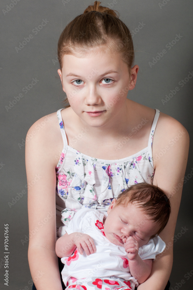 Young girl holding a baby Stock Photo Adobe Stock
