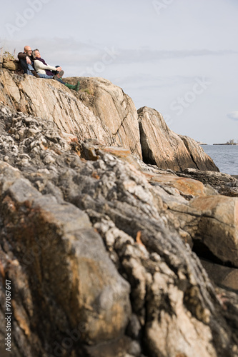 Mature couple resting on rocks © xixinxing