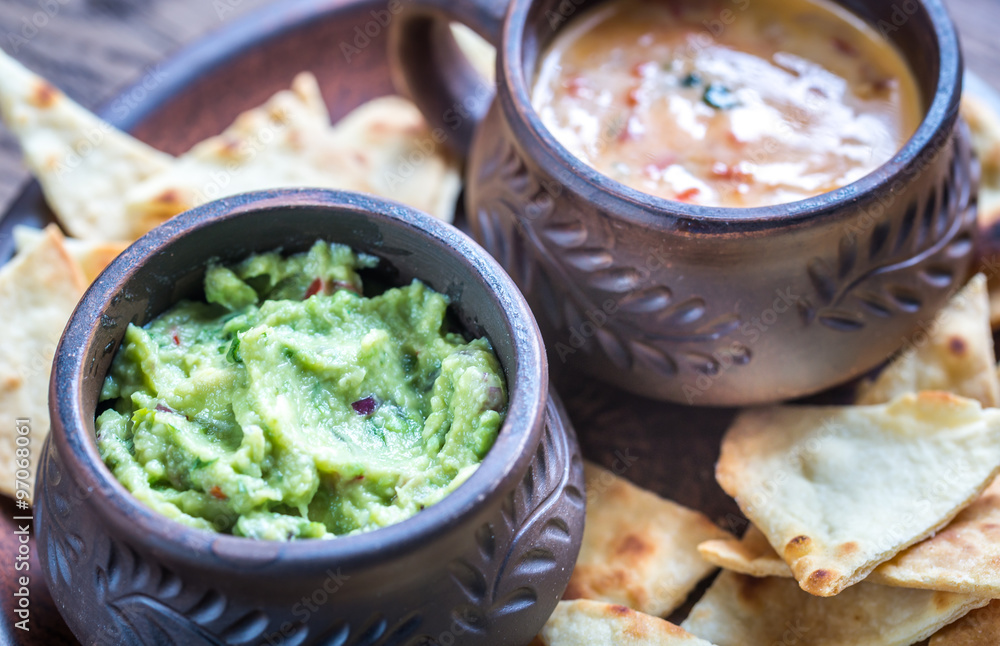 Bowls of guacamole and queso with tortilla chips Bowls of guacamole and queso with tortilla chips