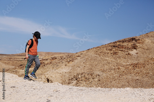 Cute 8 years old boy hiking in the desert