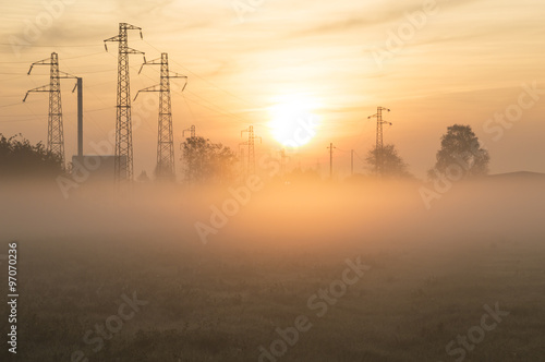 Suburban sunrise over the town  with pylons on background