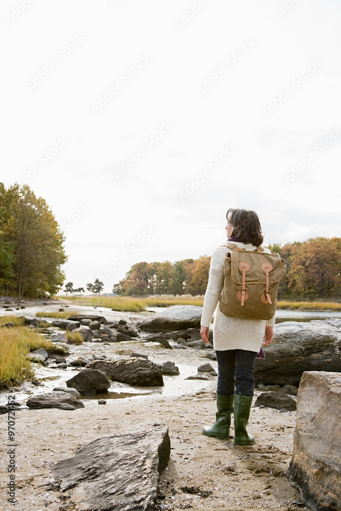 Mature hiker walking over rocks