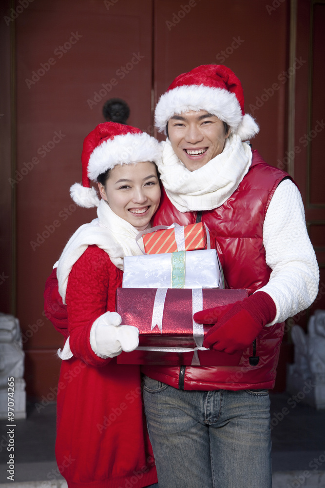 Fototapeta premium Young couple holding Christmas Gifts