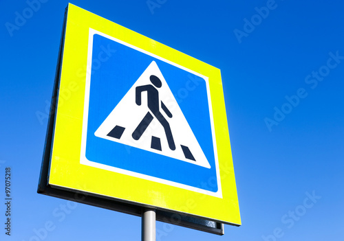 Traffic sign pedestrian crossing with blue sky in background