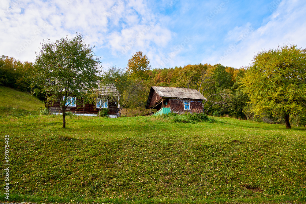 Obraz premium Mountain country village landscape with clouds and blue sky
