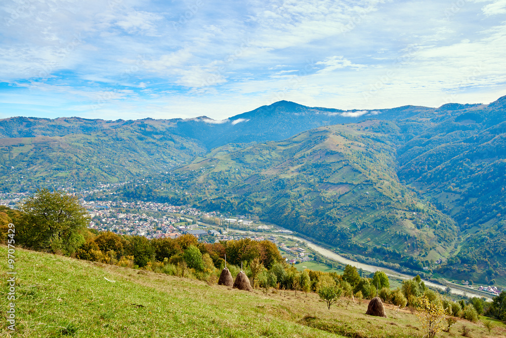 Mountain country village landscape with clouds and blue sky