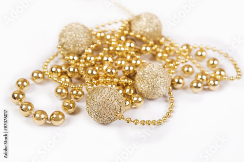Gold gift with other Christmas baubles like holiday decoration on white.