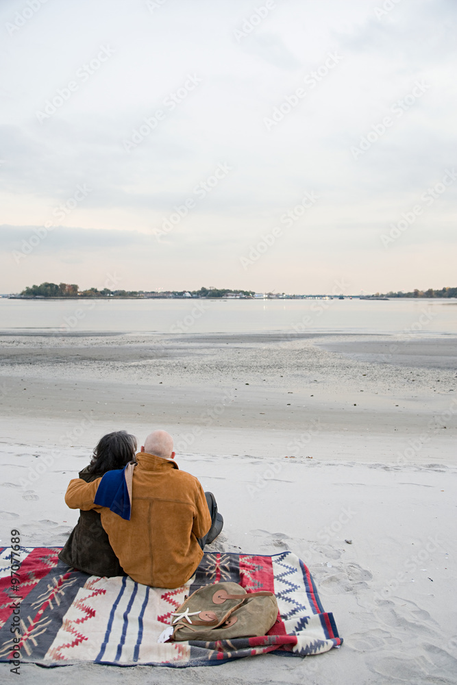 Mature couple sitting on the beach