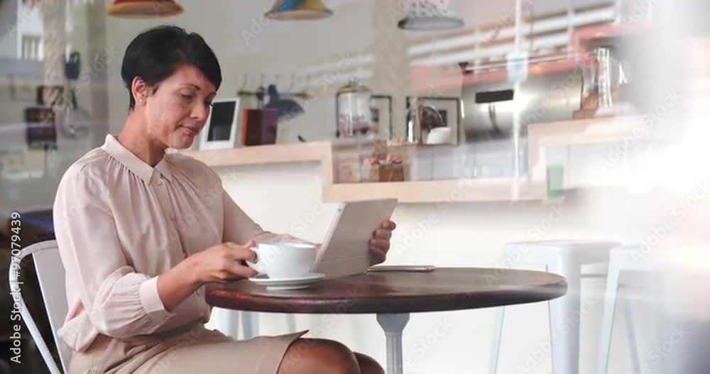 Businesswoman at a table in a cafe using tablet computer Businesswoman at a table in a cafe using tablet computer