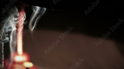 A smoke hovering in the air in the light of a table-lamp photo