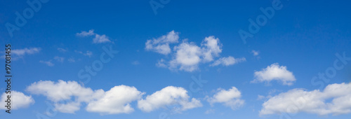 Cloudscape over horizon. White heap clouds in the blue sky.