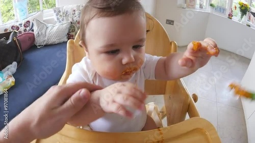 Point Of View Shot Of Baby Being Fed In High Chair photo