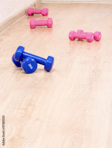 Stacks of Fitness Dumbbells on Floor in Gym Center