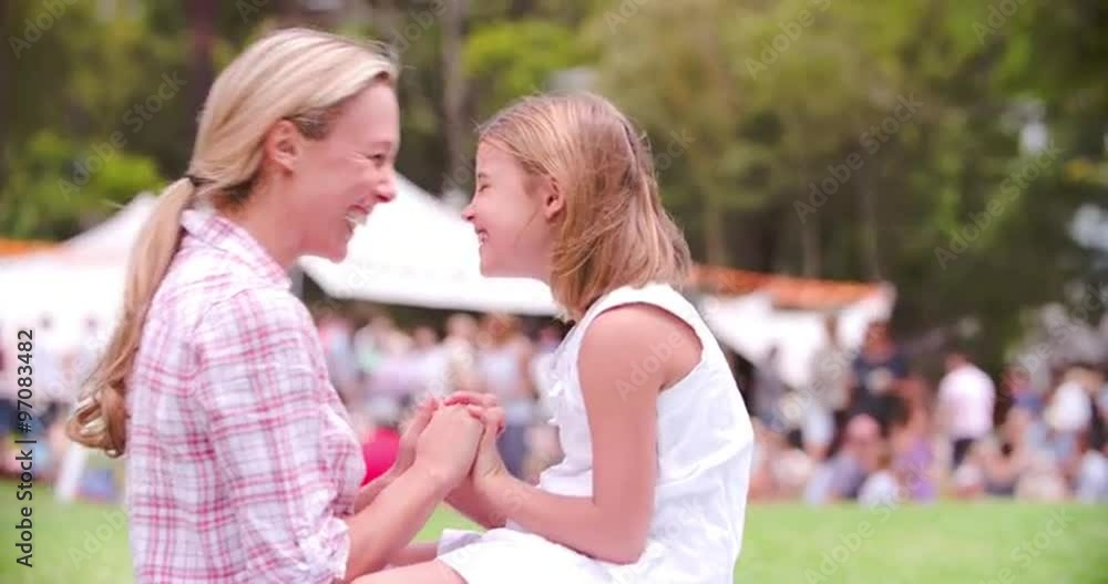 Mother and daughter Eskimo kissing at an outdoor event Mother and daughter Eskimo kissing at an outdoor event