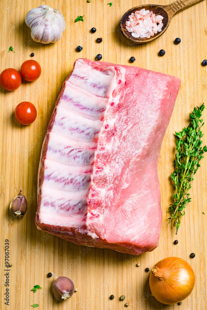 Fresh raw pork chop, spices, vegetables and herbs on wooden background, top view Fresh raw pork chop, spices, vegetables and herbs on wooden background, top view