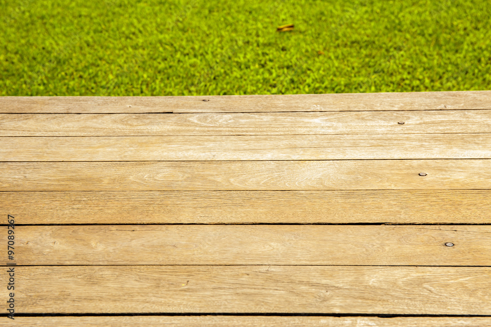 Wood planks floor with green grass on the background. Wood planks floor with green grass on the background.