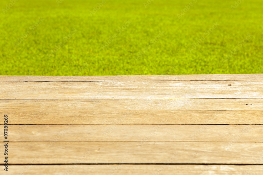 Fototapeta premium Wood planks floor with green grass on the background.
