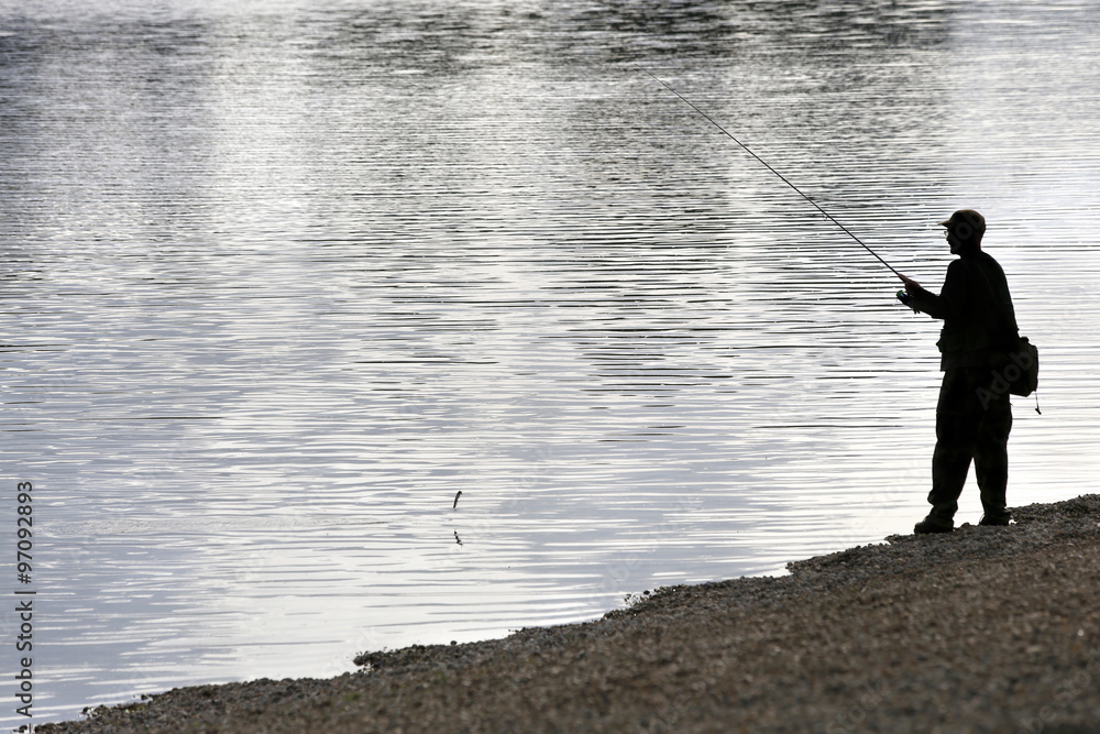 Silhouette of man on lake beach fishing Silhouette of man on lake beach fishing