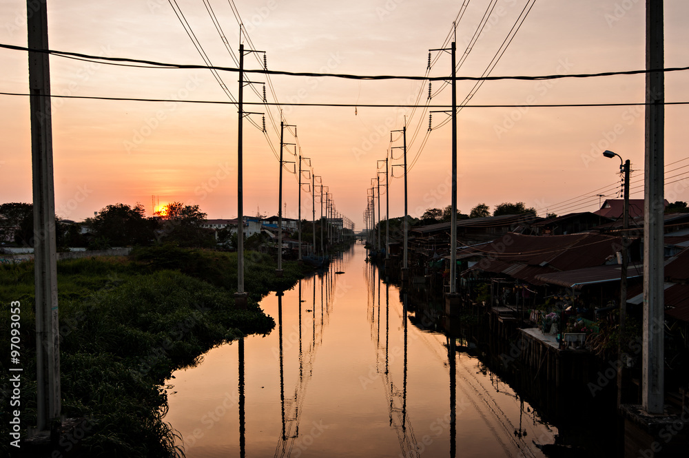 Sunset canal view with electricity post