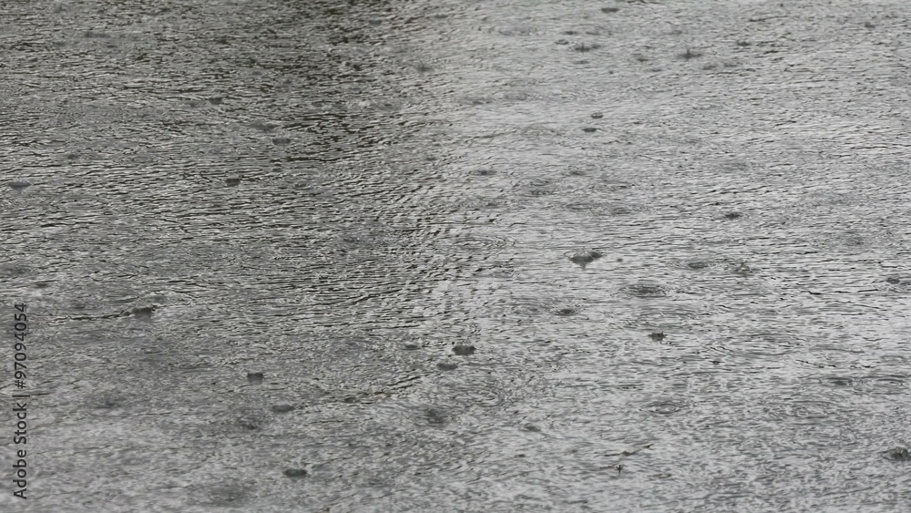 Raindrops falling on the asphalt.
