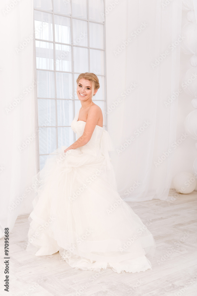 Smiling bride standing in white wedding dress Smiling bride standing in white wedding dress
