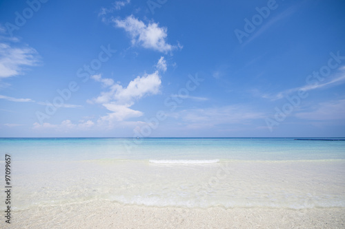 tropical beach with blue sky and calm blue sea surf