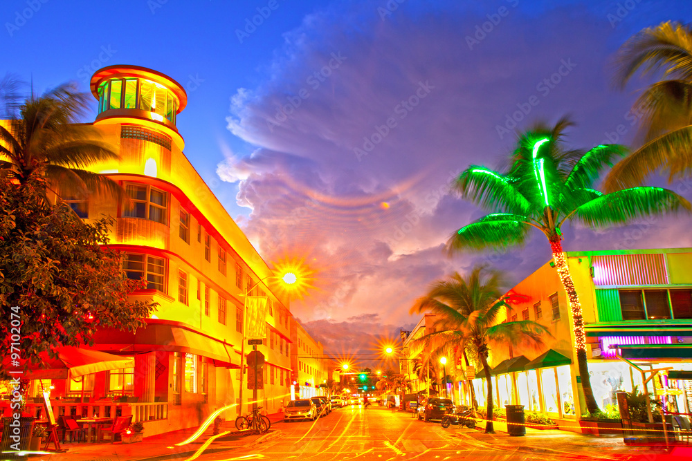Fototapeta premium Miami Beach, Floryda Hotele i restauracje o ruchu ulicznym o zachodzie słońca na Ocean Drive, znane na całym świecie miejsce z życia nocnego, pięknej letniej pogody i dziewiczych plaż