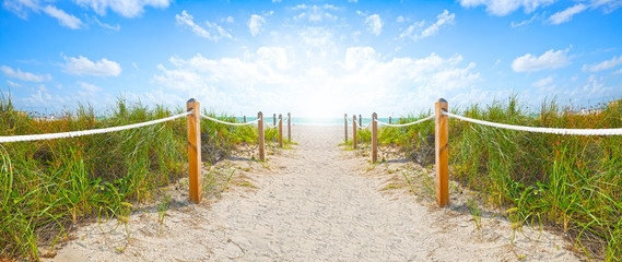 Path of sand going to the beach and ocean in Miami Beach Florida , on a beautiful summer morning with blue sky