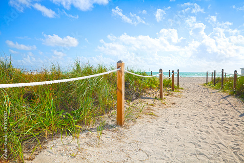 Path of sand going to the beach and ocean in Miami Beach Florida , on a beautiful summer morning with blue sky